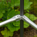 Aluminum cage rods bolted to a post with netting in a garden.