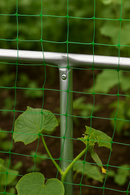 Aluminum cage rod joined to a vertical post with green netting supporting climbing vegetable plants in a garden.