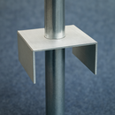 Metal ground plate supporting a vertical pole on a solid surface.