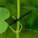 Plastic garden tie securing a cucumber plant stem to green support netting.
