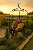 Couple sitting under British-made garden arbour bench