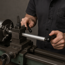 Person operating a metal lathe to machine an aluminium rod.