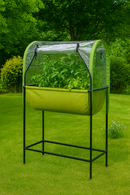Raised fabric planter with clear cover on lawn, full of leafy greens