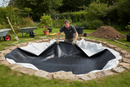 Professional Landscaper Installing Pond Liner